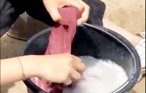 Thumbnail preview image for the video titled: Girl washing clothes in a bucket