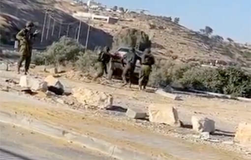 Thumbnail preview image for the video titled: Israeli soldiers, who confiscated cars from Palestinians in Hebron, push the cars they confiscated into a valley