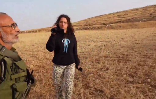 Thumbnail preview image for the video titled: Armed settler in IDF uniform chases Palestinian shepherd from the latter's land