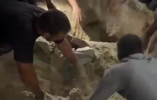 Thumbnail preview image for the video titled: Civilians dig in the sand with their bare hands searching for survivors