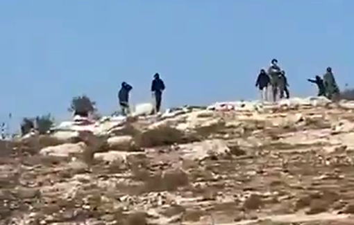 Thumbnail preview image for the video titled: Israeli settlers throwing stones at Palestinians with the accompaniment of a soldier.